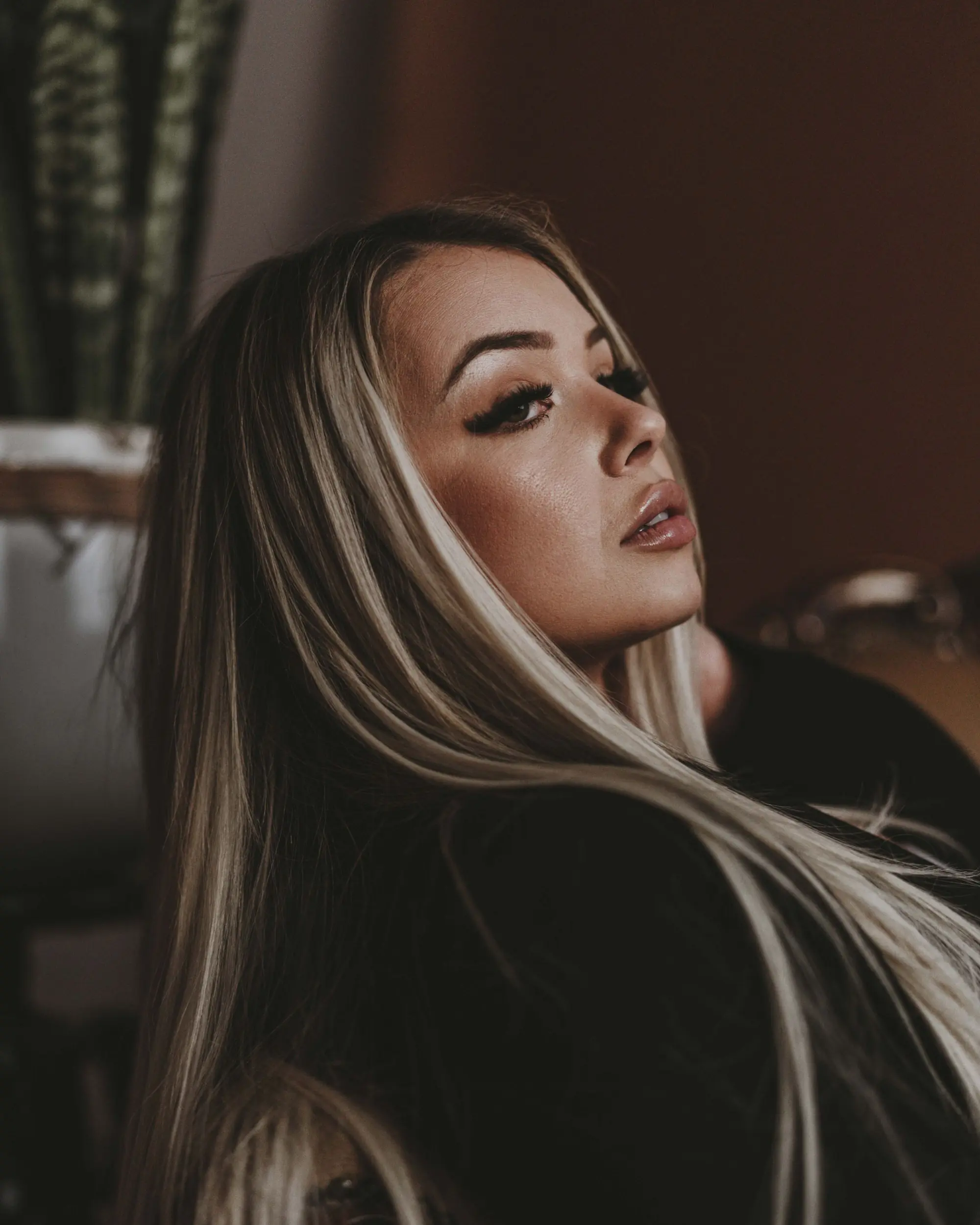 Woman with long, glossy balayage hair in soft, warm light
