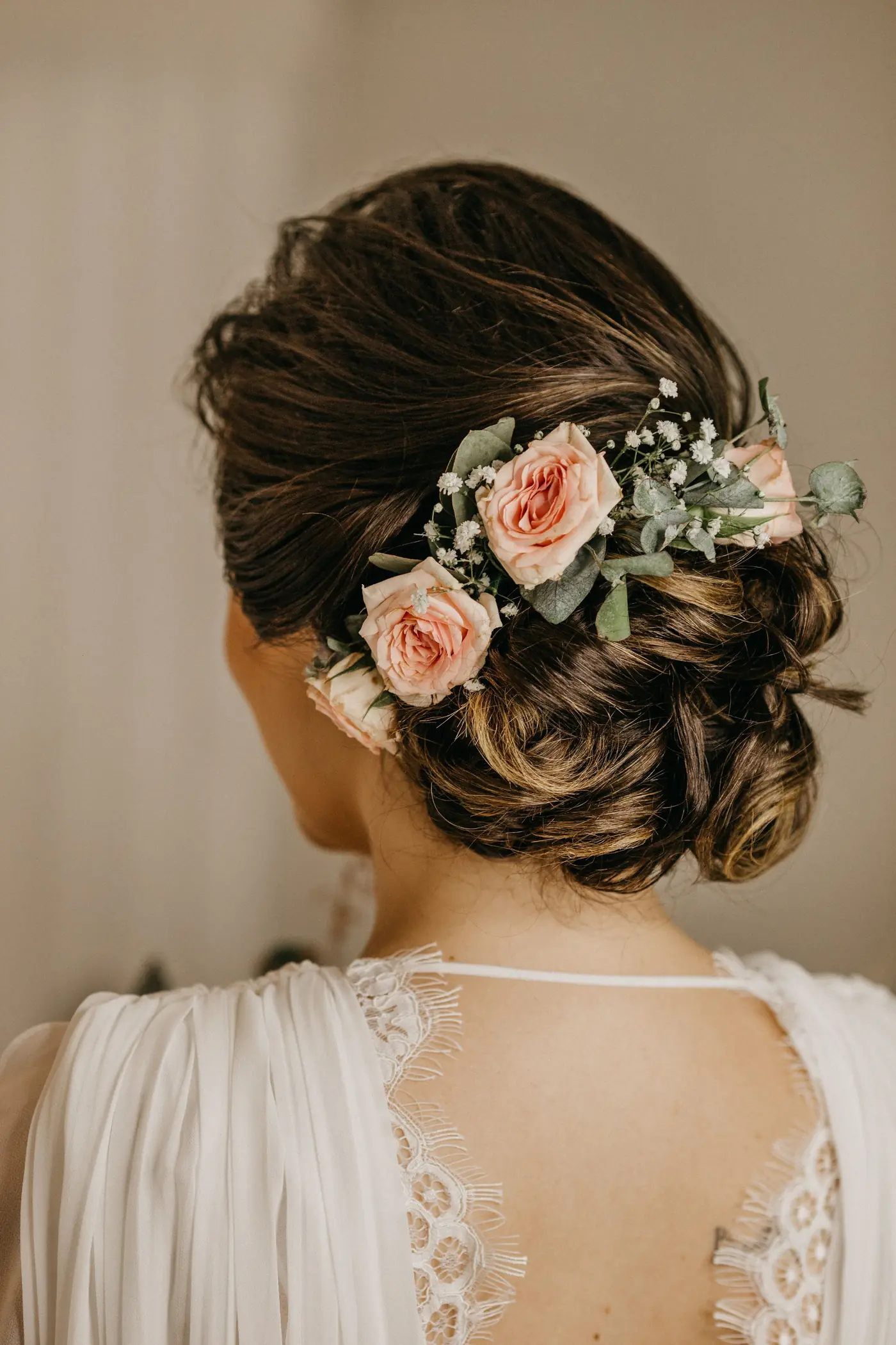 Bridal updo with fresh roses, seen from behind