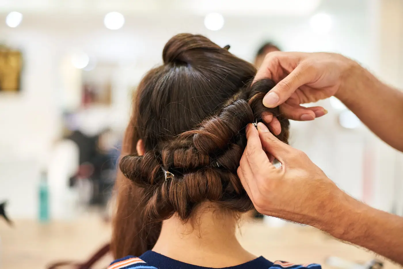 Stylist setting soft curls in a client’s hair