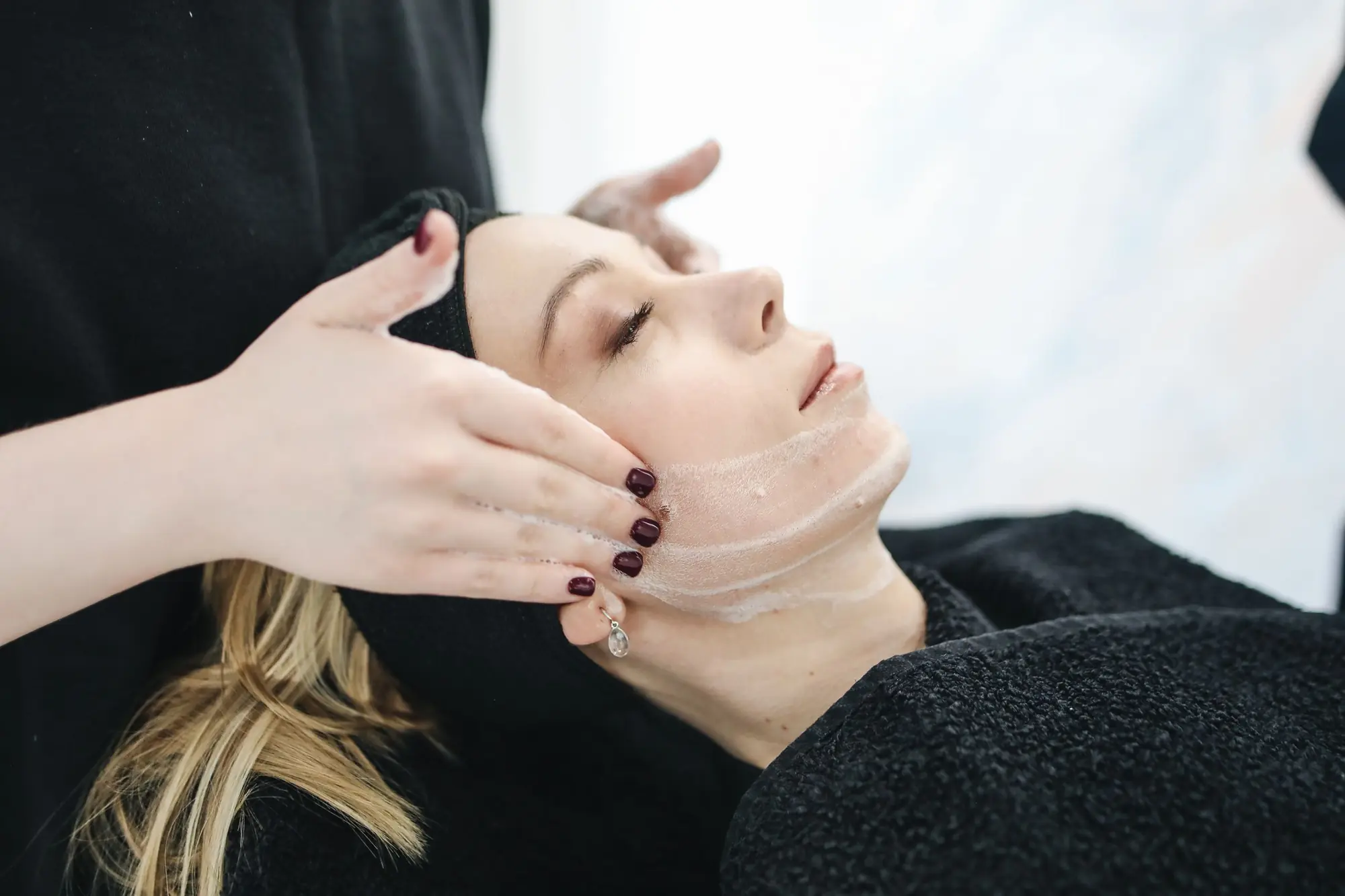 Therapist giving a calm facial treatment in a quiet room